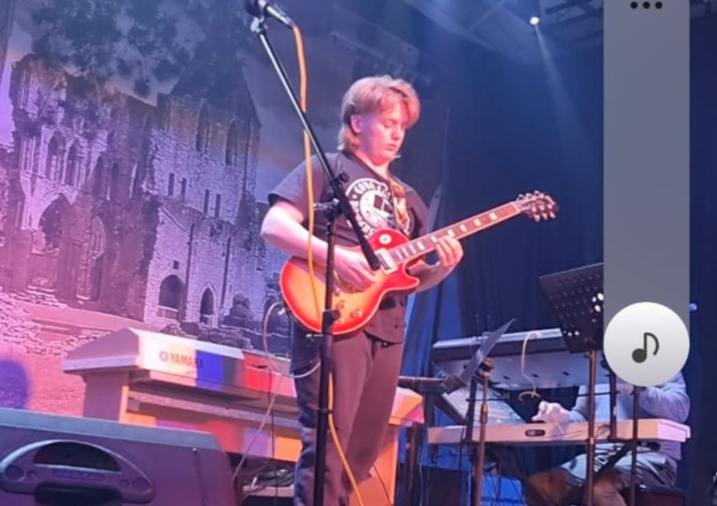 Leo onstage during a performance at Peppercorns. Beginner electric guitar student learning guitar in St Neots